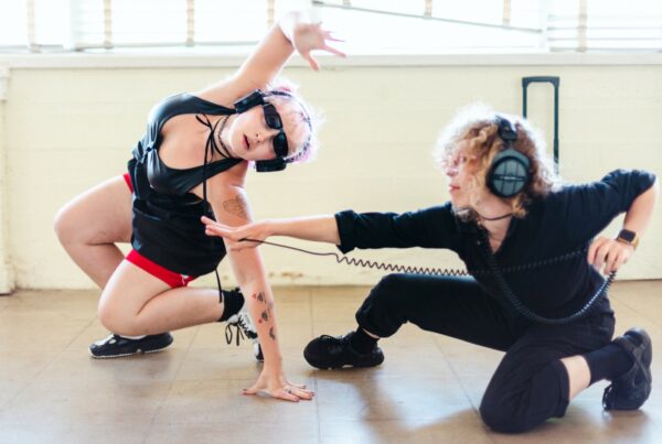 Two dancers wearing headphones and performing
