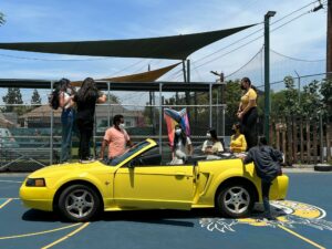 Dancers performing on a yellow Mustang