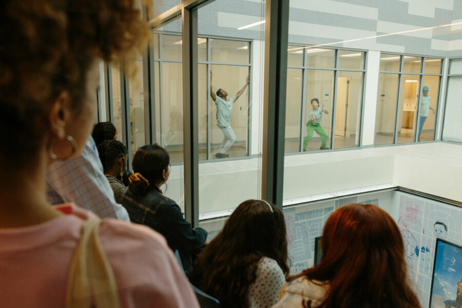 Woman watching a dance performance through a window