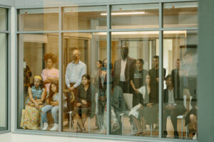 People watching a performance through a glass window